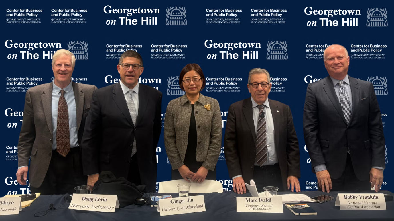 Panelists standing behind a table at a